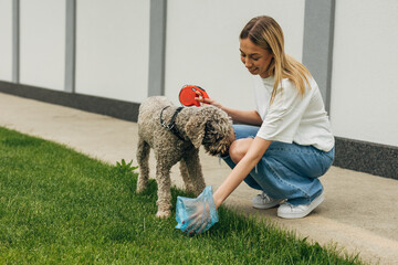 Caucasian woman cleaning up dog droppings
