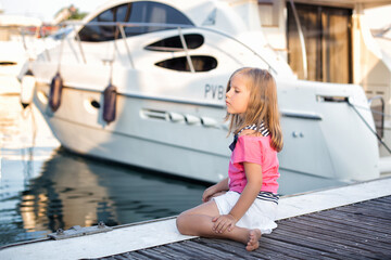 Fototapeta na wymiar Girl sitting near the yacht in summer 