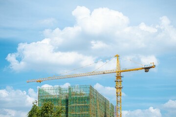 Low angle shot of a construction of a modern building against a cloudy blue sky