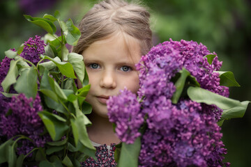 Girl with lilac bouquet in the park