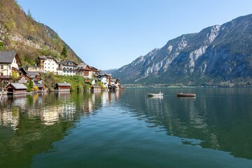 Fototapeta na wymiar Lakeshore with some floating boats in Hallstatt, Austria