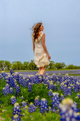 A Lovely Brunette Model Poses In A Field Of Bluebonnet Flowers In A Texas Prarie