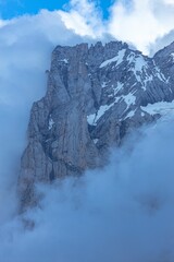 Fototapeta na wymiar Vertical of the Wetterhorn peak of the Swiss Alps captured surrounded by smoky clouds