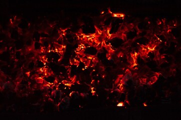 Fototapeta na wymiar Glowing and flaming hot charcoal briquettes