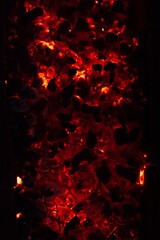 Fototapeta na wymiar Vertical top view closeup of hot smoldering ashes form a fire