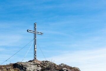 Huge summit cross under a bright blue sky in the Bavarian woods in Germany