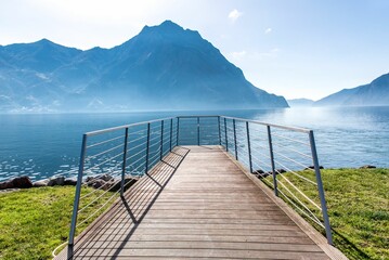 Wooden deck on the lake with the mountains in the background.