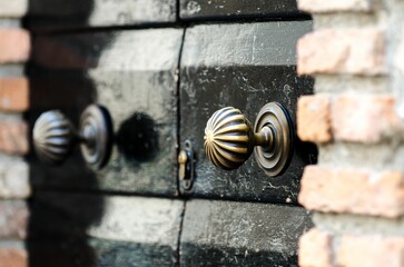 Closeup of vintage metal Doorknobs on a old black wooden door