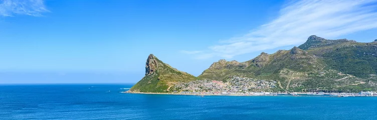 Fototapeten Panoramic shot Hout Bay with rugged coastal mountain and blue sea © Burgie/Wirestock Creators