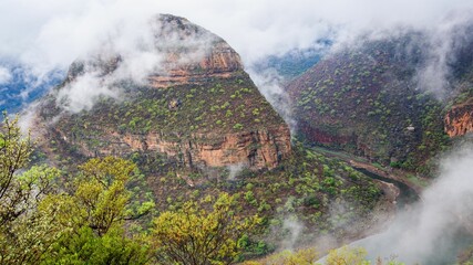 Scenic nature view of meandering river between mountain on a foggy day