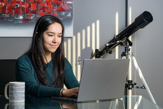 South Asian Woman Sitting At A Desk, Working On Her Laptop