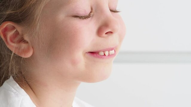 Side view portrait of a cute young girl. A smile with an overbite and crooked teeth. A child with an angelic gentle smile. girl dreams