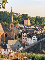 Scenic view of tourist town Saarburg in Germany, St. Lawrence church and city river with waterfall and water mill
