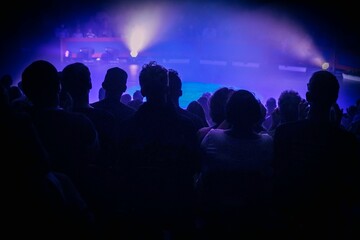 Spectators in a circus with purple lights in the background © Romy Mclegne1/Wirestock Creators