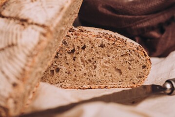 Closeup shot of freshly baked and sliced bread with flour and a knife on the table