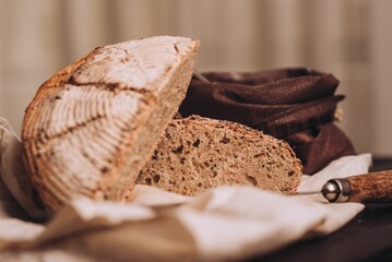 Closeup shot of freshly baked and sliced bread with flour and a knife on the table