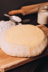 Dough with flour and roller on table