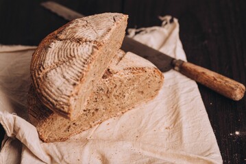 High-angle of freshly baked and sliced Italian bread with flour and a knife on the table