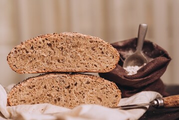 Freshly baked and sliced bread with flour and a knife on the table