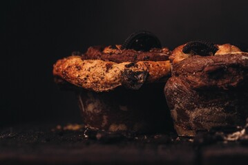 Chocolate pastries on a table, with crumbs and broken pieces scattered around the surface