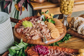 Abundant selection of cured meats, crackers, and olives served on decorative platters