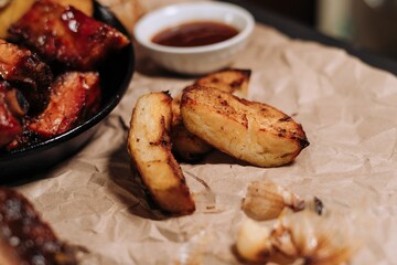 Closeup of tasty village potatoes and barbecue meat on the pan