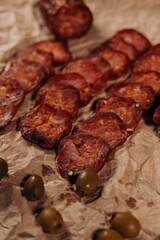 Vertical shot of freshly grilled barbecue with olives on the blurred background