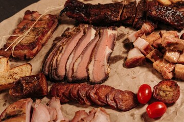 High angle shot of different types of sliced meat and barbecue put on the table