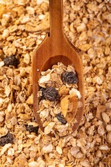 Close-up shot of a scoop filled with a variety of granola and raisins