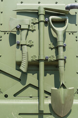 Tools attached to the side of a green armored vehicle