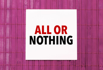 blank note pad with text ALL OR NOTHING on blue wooden background