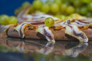 Closeup shot of cut bacon slices with grapes