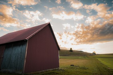 Beautiful shot of a cloudy sunset sky over a rural hill with a wooden barn in Baden-Wurttemberg