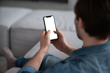 Young man user customer hold smartphone mock up transparent screen in hand use mobile shopping app, check social media news