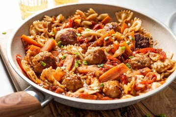 Spaghetti and meatballs dish with onion, red pepper, garlic, tomatoes, carrot and meatballs