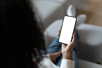 Young woman user customer hold smartphone mock up transparent screen in hand use mobile shopping app, check social media news