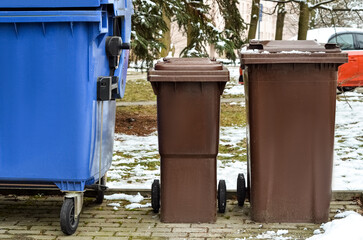 View of garbage containers in city on winter day