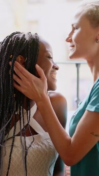 Lesbian woman kissing the forehead of her partner at home