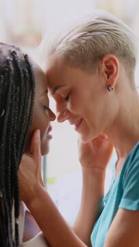 Lesbian couple about to kiss passionately on the balcony