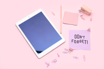 Don't forget reminder with stationery and tablet computer on pink background