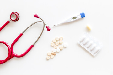 Various medical equipment - stethoscope with thermometer and pills
