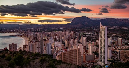 Scenic view of the coastline town Benidorm under cloudy pinky sunset sky, Spain