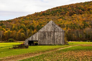 Wooden old building in background of mountain with autumn dense trees in New Hampshire