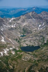 Naklejka na ściany i meble Aerial scene of Rocky mountain hiking on Colorado trails with a lake under blue sky
