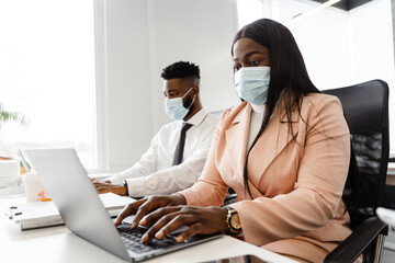 Young multiracial people in business suits wearing mask working together at office