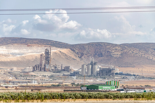 Oggaz, Mascara, Algeria- May 3, 2023: El Kader Plast factory, recycling plant for polypropylene (PP) plastic and high-density polyethylene (HDPE) plastics and the Lafarge-Holcim cement plant afar.