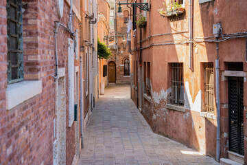 Fototapeta na wymiar Scene with the narrow streets and the old medieval red brick buiuldings in Venice, Italy.