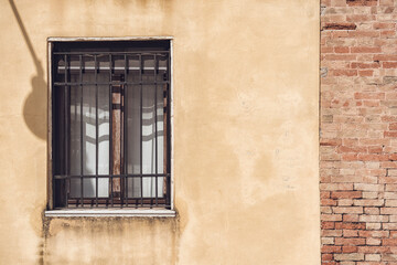 Fototapeta na wymiar Close up detail with old medieval architecture venetian window. Security metal bars and grill