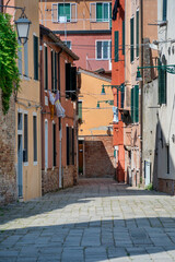 Fototapeta na wymiar Scene with the narrow streets and the old medieval red brick buiuldings in Venice, Italy.