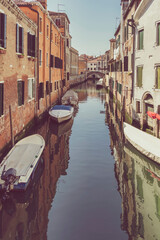Fototapeta na wymiar Picturesque Scene from Venice with many boats parked on the narrow water canals.